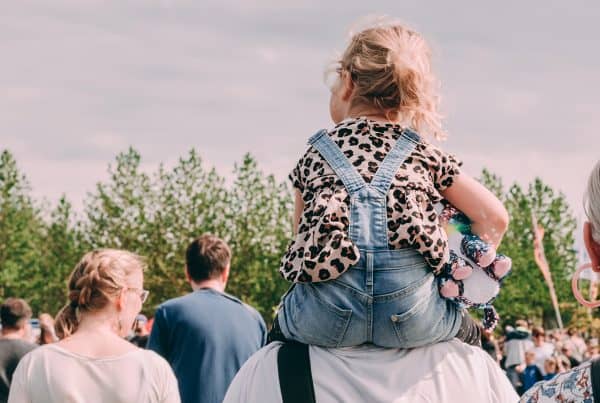 Child rides on grandfather's shoulders at family event